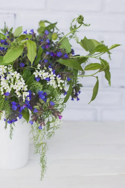 Wild forest meadow bouquet of cherry, lungwort, wild herbs in can on white background