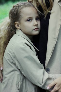 Üzgün kız 7 yaşında mavi gözlü kameraya, seyir annesi sarılma