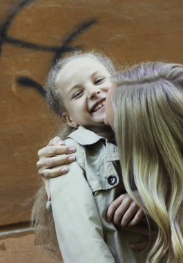 Mutlu kız sarı saçlı gülen ve anne ile sarılma 7 yıl