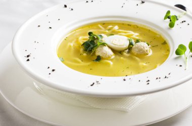 Tavuk çorbası köfte, bıldırcın yumurtası ve beyaz tabak erişte