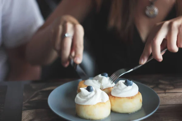 クリームとブルー プレート ナイフとフォークで女性の手にブルーベリーのチーズケーキ — ストック写真