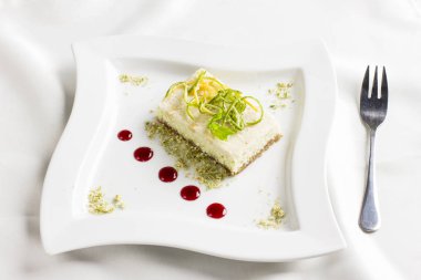 Limon ve kireç ile çiğ gıda tatlı pasta beyaz plaka üzerinde meyve şekerlenmiş