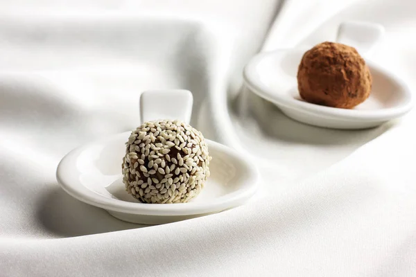 Homemade healthy raw candy truffle with sesame and chocolate on white background