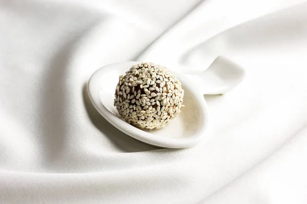 Homemade healthy raw candy truffle with sesame and chocolate on white background