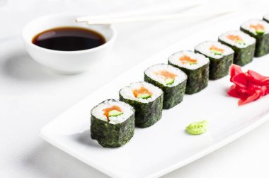 Japon Suşi rulo somon ve salatalık ile beyaz arka plan üzerinde avokado