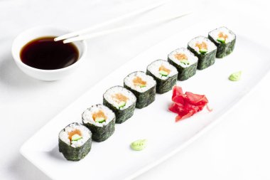 Japon Suşi rulo somon ve salatalık ile beyaz arka plan üzerinde avokado