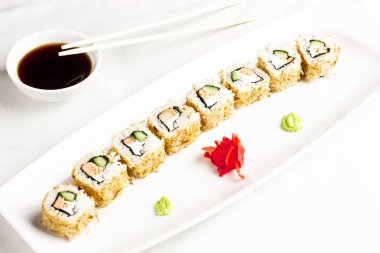 Japon Suşi rulo somon ve salatalık ile beyaz arka plan üzerinde avokado