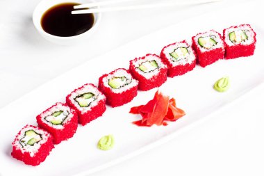 Japon Suşi avokado ile uçan balık kırmızı havyar içinde beyaz plaka üzerinde rulo