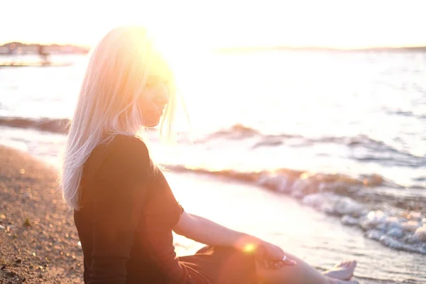 Junge Blonde Frau Sitzt Ufer Und Schaut Auf Das Wasser — Stockfoto