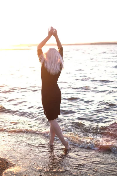 Junge Blonde Frau Schwarzem Kleid Hob Die Hände Strand Rückansicht — Stockfoto