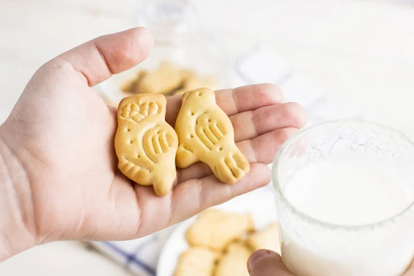 Cookies birds and a glass of milk in the hand of the child, children\'s Breakfast