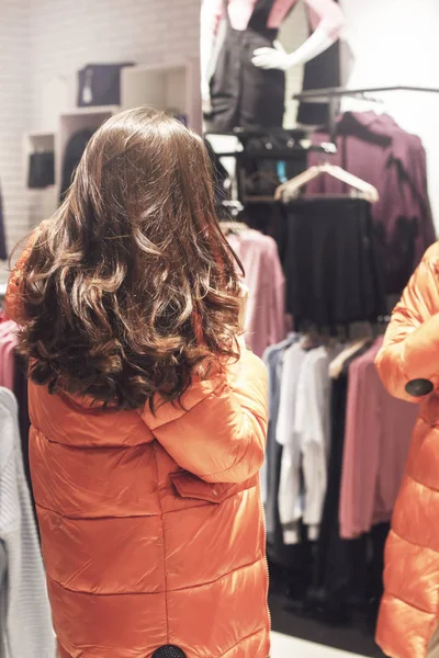 Jovem Comprador Escolhe Laranja Inverno Jaqueta Loja — Fotografia de Stock