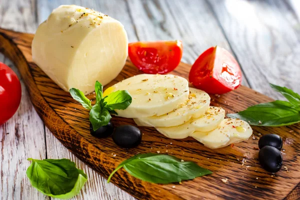 木製の背景にトマトとバジルのモッツアレラ チーズ — ストック写真