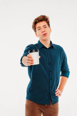 Beyaz arka plan üzerinde gitmek için kahve tutan çekici genç adam