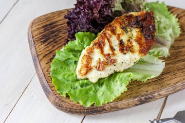 Baharat taze marul yaprakları ile ahşap tahta üzerinde ev yapımı Izgara Hellim peyniri