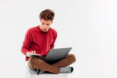 Genç öğrenci dizüstü ve tablet beyaz arka plan üzerinde çalışma ile