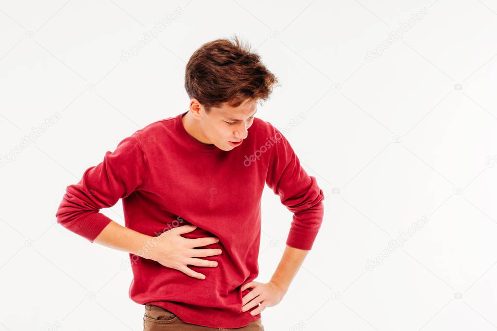 Young man holding liver, experiencing pain, on white background