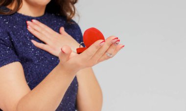 Güzel esmer kız evlenmek, izole gri arka plan üzerinde yakın çekim için alınan yüzük teklifi şaşırttı