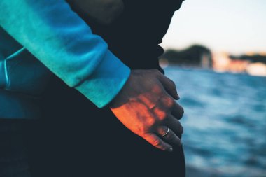 Kırpma fotoğraf elini kızın belden aşağı su arka plan üzerinde hugs.