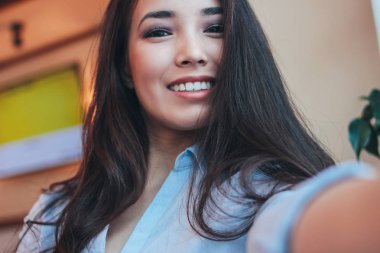 Asyalı kız alma selfie kafede ön kameraya gülümseyen güzel sevimli esmer