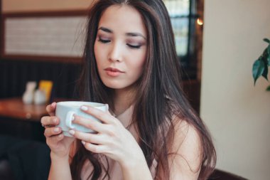Kafede kahve ile kahvaltı büyüleyici romantik esmer Asyalı kız gülümseyen güzel vardır