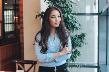 Güzel büyüleyici romantik esmer uzun saç gülümseyen Asyalı kız yakınındaki kafede pencere portresi