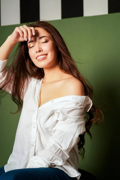 緑の背景に白のシャツで黒い長い髪とセクシーな官能的な笑みを浮かべてアジア若い女性の美容ファッション ポートレート — ストック写真