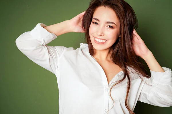 緑の背景に白のシャツで黒い長い髪とセクシーな官能的なアジアの若い女性の美容ファッション ポートレート — ストック写真