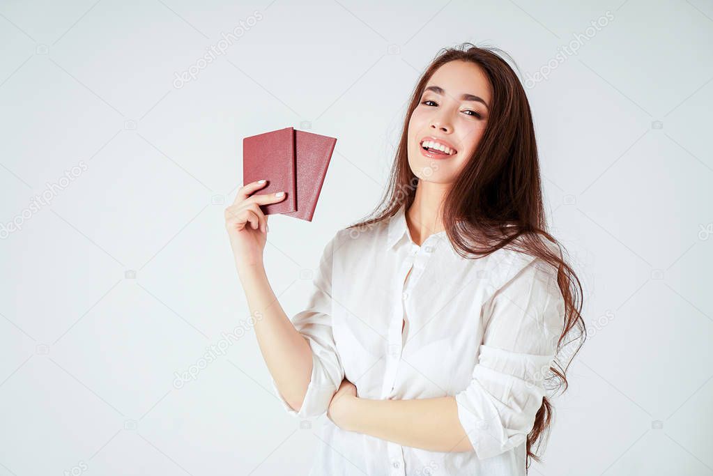 Happy smiling asian young long hair woman with two passports on white background isolated
