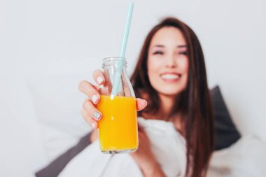 Cam mutlu güzel gülümseyen Asyalı kız genç kadın, elinde portakal suyu sağlıklı rahat sabah
