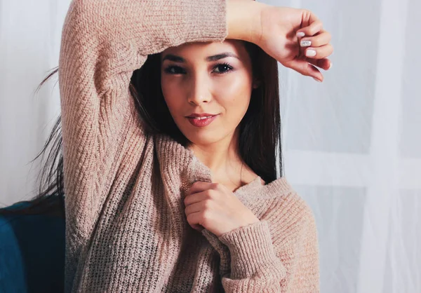 居心地の良いベージュ色のセーターに黒い長い髪と官能的な笑みを浮かべてアジアの女の子若い女性の率直な肖像画 — ストック写真
