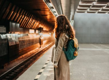 Genç kadın kıvırcık kırmızı kafa kız Gezgin sırt çantası ve harita ile metro istasyonu