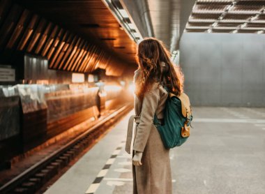 Genç kadın kıvırcık kırmızı kafa kız Gezgin sırt çantası ve harita ile metro istasyonu