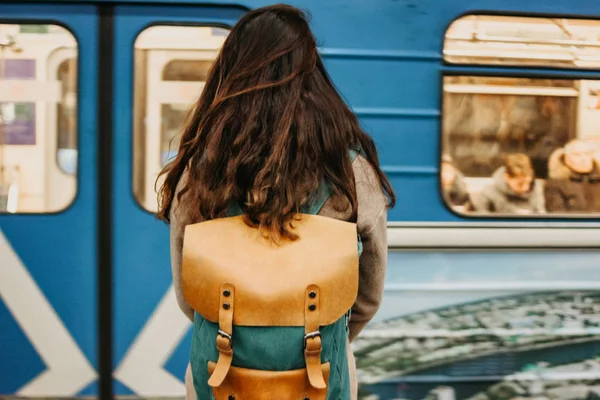 Молодая женщина кудрявая красная голова девушка путешественник с рюкзаком и карта в метро станции перед поездом — стоковое фото
