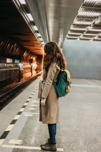 Молодая женщина кудрявая рыжая голова девушка путешественник с рюкзаком и карта в метро станции — стоковое фото