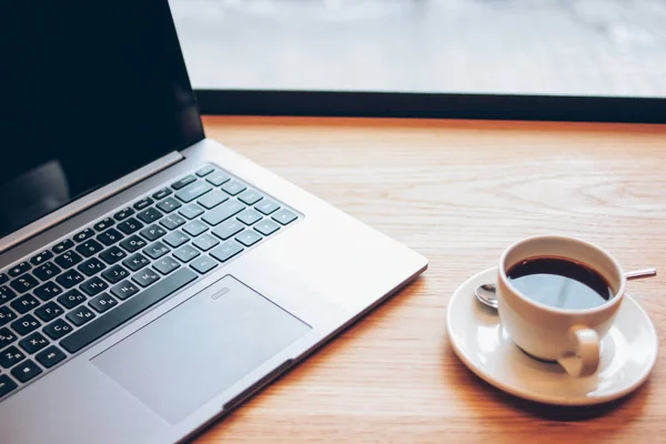 Nyílt laptop és egy csésze kávét az asztalra a kávézóban, freela — Stock Fotó