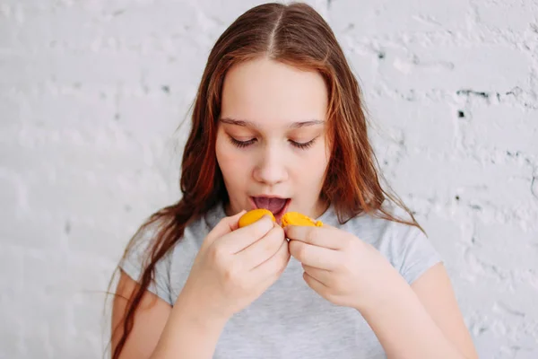 Teen girl has two macaroons at once, the concept of childhood obesity and overeating