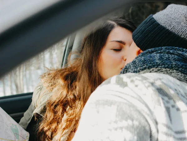 Le couple embrassant un jeune homme et une jeune femme dans la voiture avec une carte papier. Voyage histoire d'amour — Photo