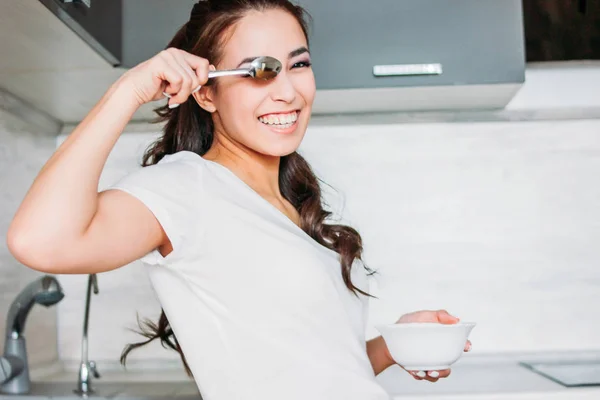 De mooie lachende grappig Aziatische meisje slanke jonge vrouw licht ontbijten in haar keuken — Stockfoto