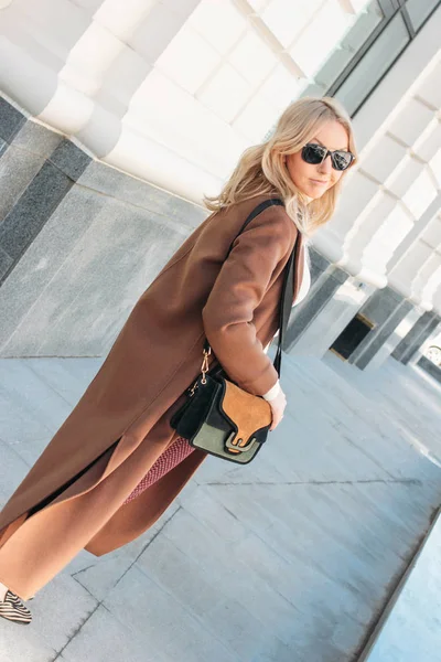 Mulher elegante moda vestindo casaco bege com cabelo louro encaracolado na rua — Fotografia de Stock