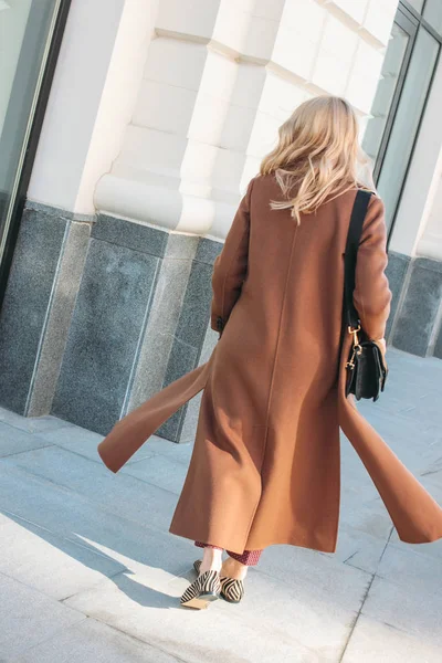Mulher elegante moda vestindo casaco bege com cabelo louro encaracolado de volta na rua — Fotografia de Stock
