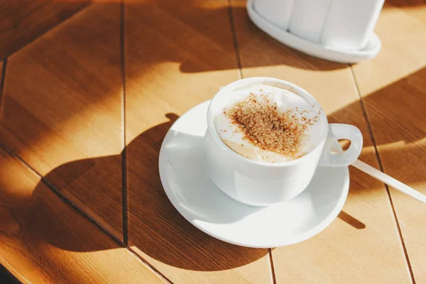 Чашка кофе с пеной и корицей на деревянном столе. Жёсткое утро — стоковое фото