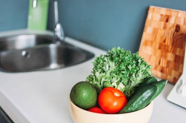 Taze mevsim sebze salatalıklar, domates, evde mutfak masasında yemeklerde yeşillikler