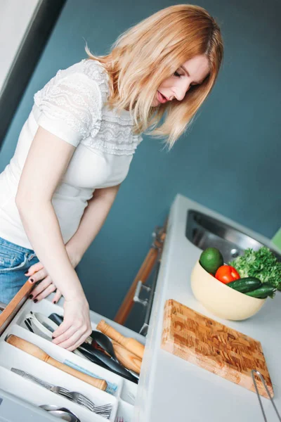 Blonde volwassen vrouw koken in de keuken thuis — Stockfoto