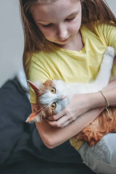 Linda chica adolescente en camiseta amarilla con su gato blanco en casa — Foto de Stock