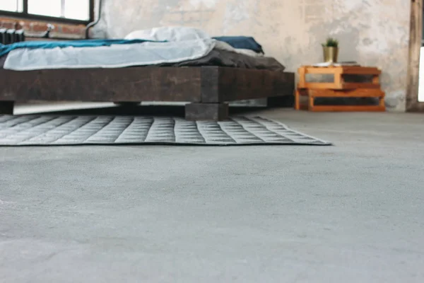 Современный интерьер эколофта в спальне, бетонный пол, размытая кровать, минимализм — стоковое фото