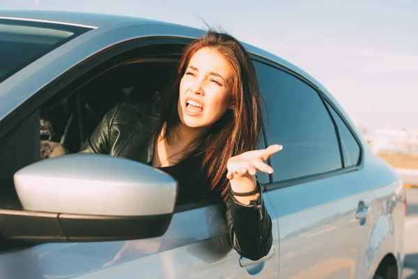 Mooie brunette lang haar boos jonge Aziatische vrouw rijden en schreeuwen in de auto — Stockfoto