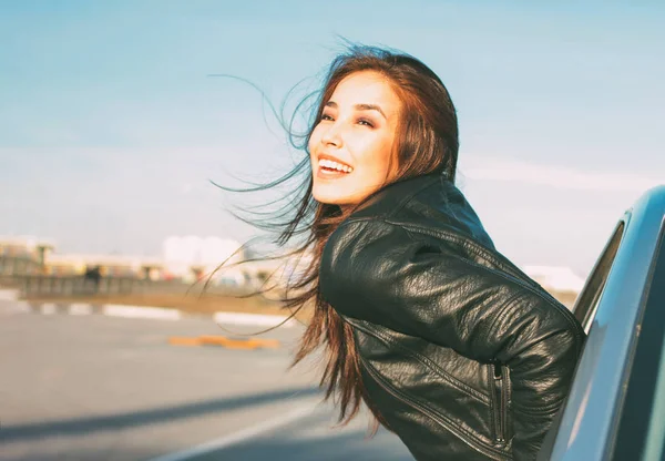 Happpy mooie charmante brunette lang haar jonge Aziatische vrouw in zwart lederen jas in auto venster bij zonsondergang — Stockfoto