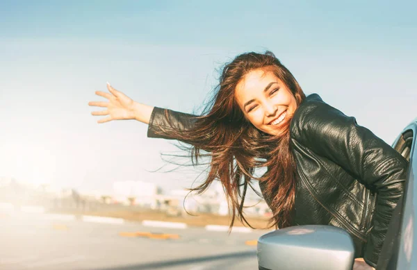 Happpy mooie charmante brunette lang haar jonge Aziatische vrouw in zwart lederen jas in auto venster bij zonsondergang — Stockfoto