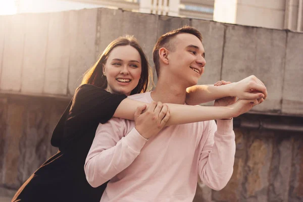 Feliz jovem casal de amigos, adolescentes, estudantes abraçando na rua da cidade — Fotografia de Stock